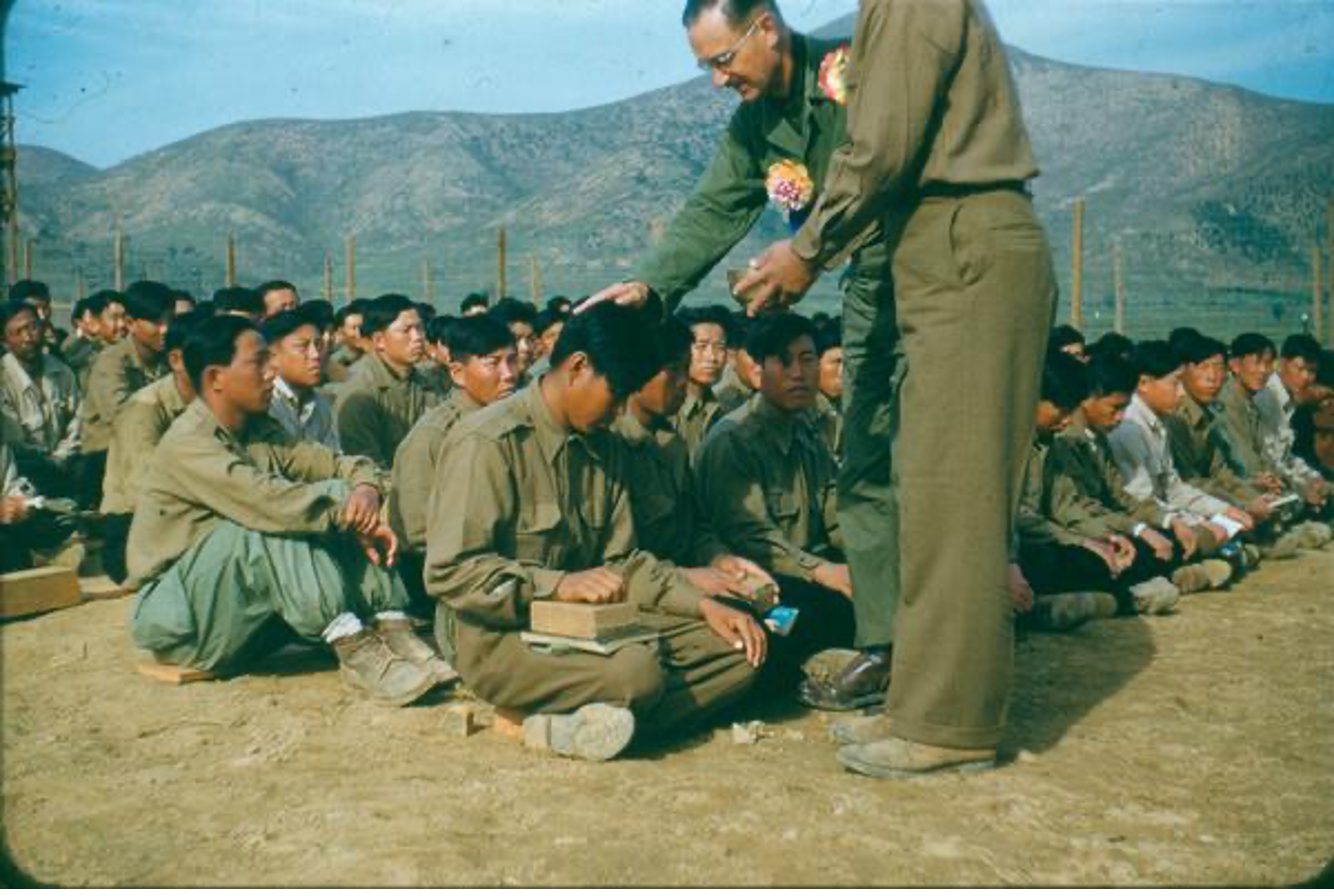 Harold Voelkel and assistant baptizing North Korean POWs.